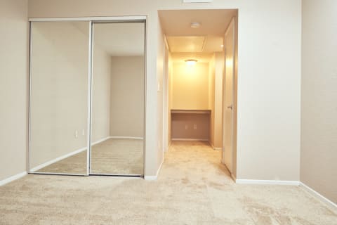 Alta Vista Apartments in Escondido, CA with Wall to wall carpet, mirrored closet, white walls, window